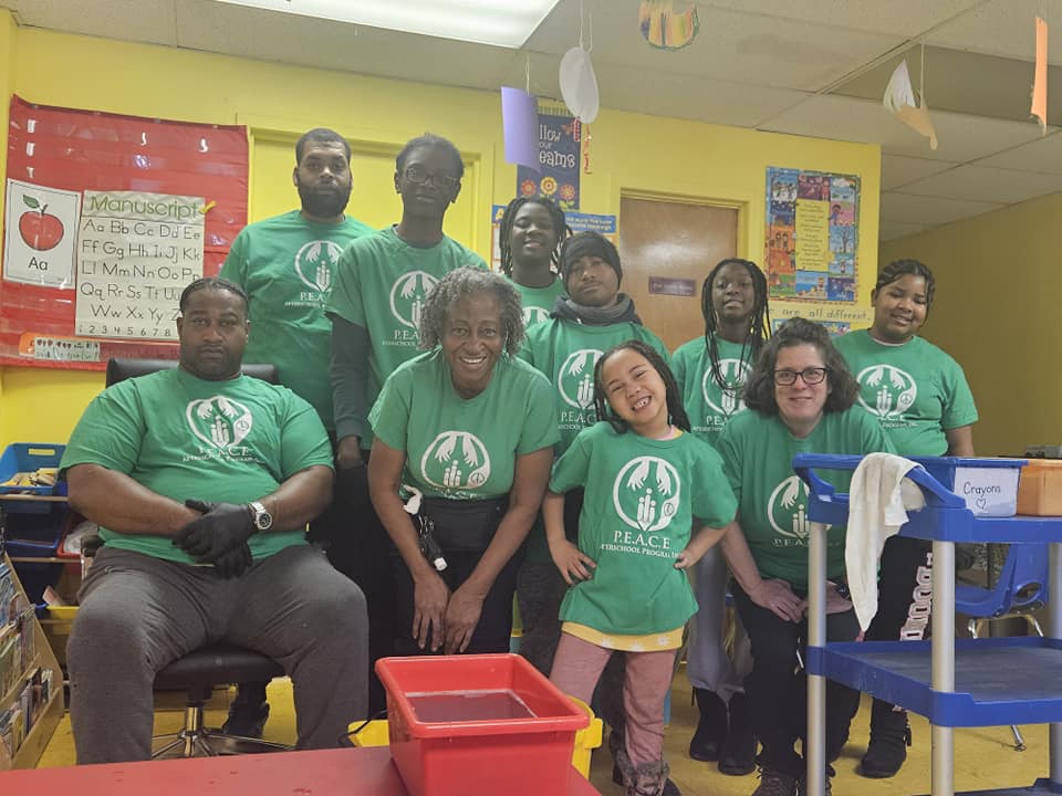 P.E.A.C.E. Afterschool Clean Up Volunteers pose for a group photo in their green t-shirts