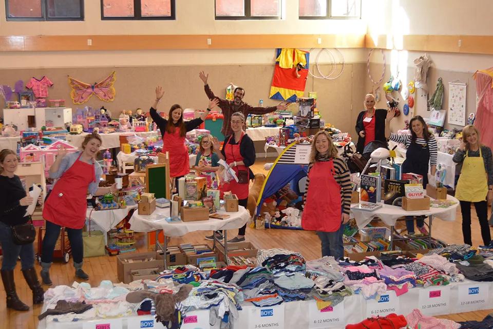 Volunteers stand around tables at Grace Church Winter Fair