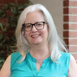 Headshot of Janet Adam: A woman wearing glasses 