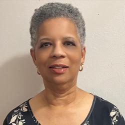 Headshot of Sharon Tucker, standing smiling