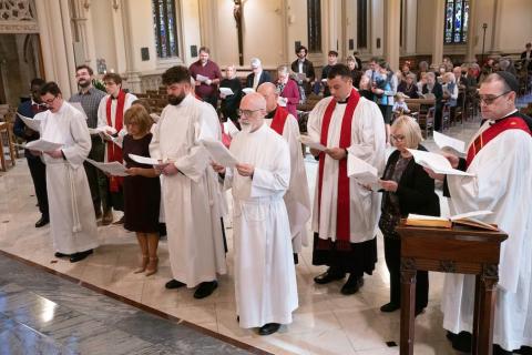 Three candidates stand during diaconate ordination
