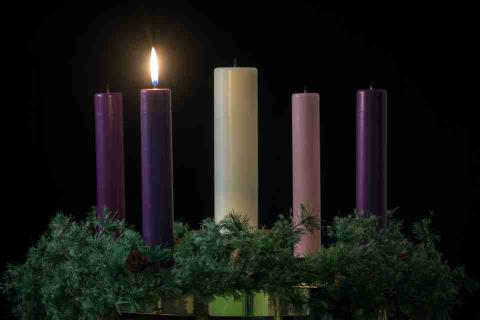 an advent wreath with one candle lit