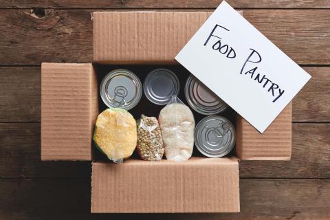 A box of groceries with a paper on top that reads "Food Pantry"