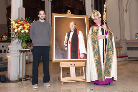 Artist Chris Provenzano stands with his father, Bishop Lawrence Provenzano, In front of the newly unveiled portrait of Bishop Provenzano