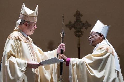 Presiding Bishop Sean Rowe receives the presiding bishop's crochure from outgoing Presiding Bishop Michael Curry